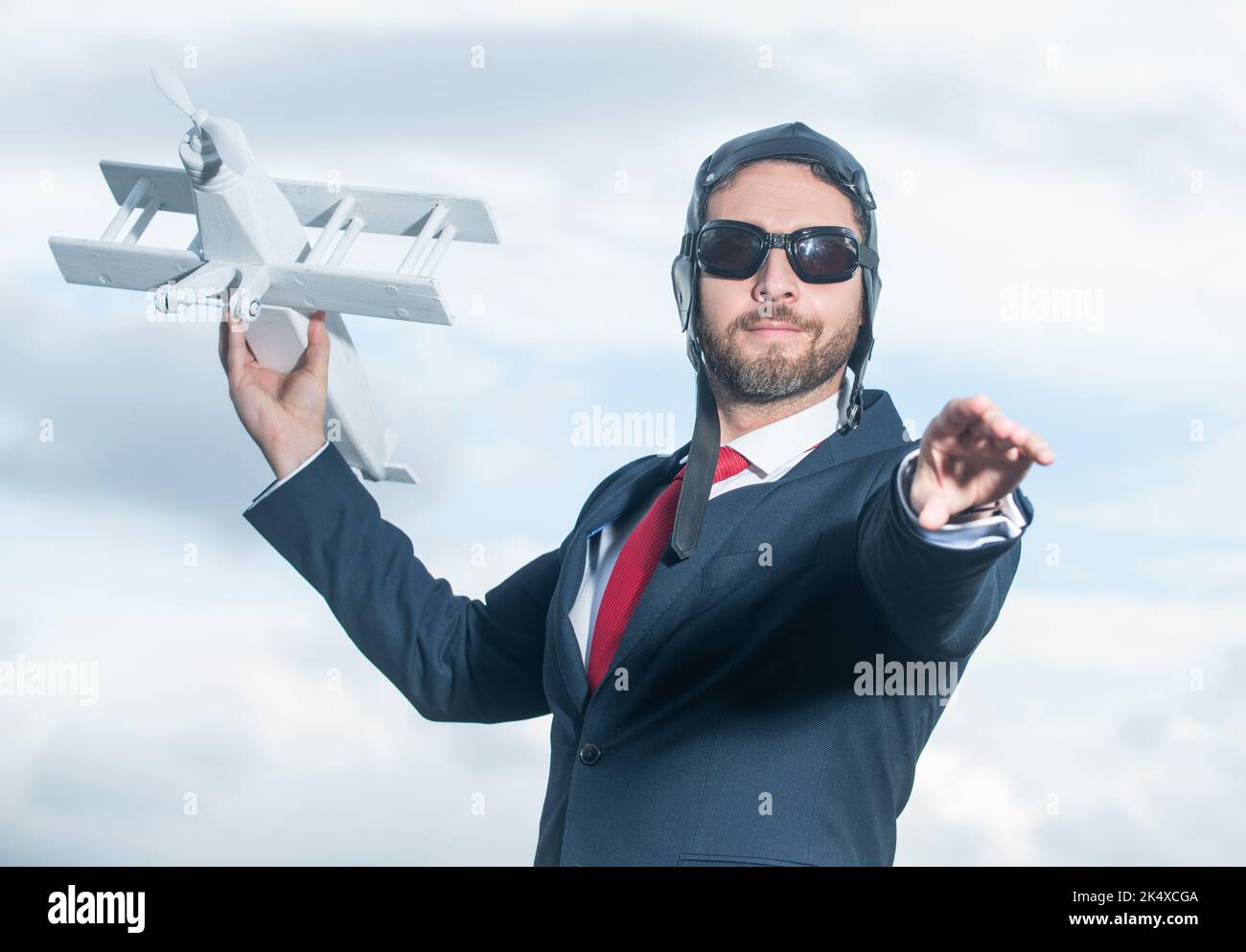 uomo d'affari in tuta e cappello pilota lancio aereo giocattolo. avvio Foto Stock