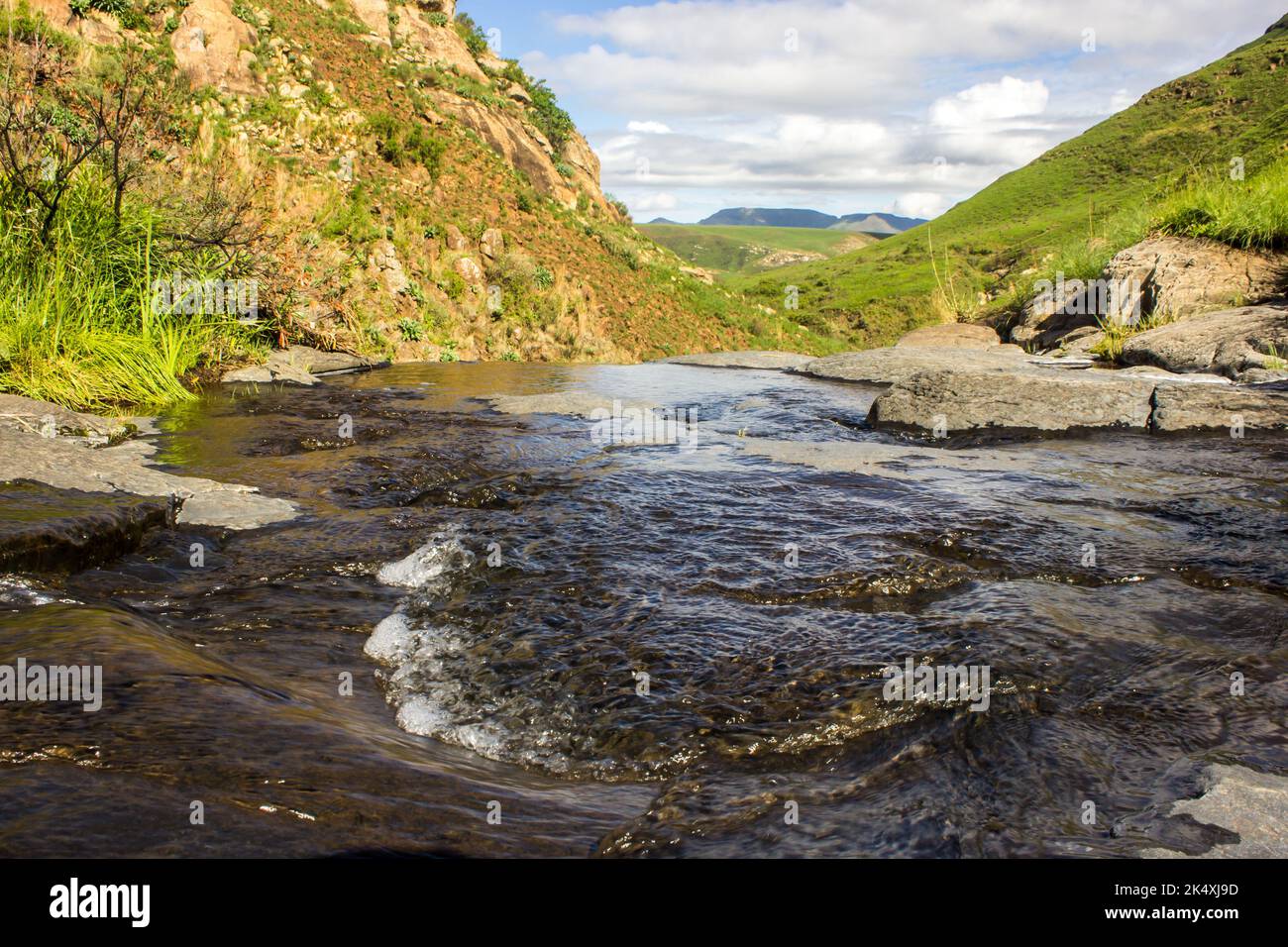 Acqua turbolenta in un piccolo ruscello sulla cima di una cascata nelle regioni remote dei Monti Drakensberg Foto Stock