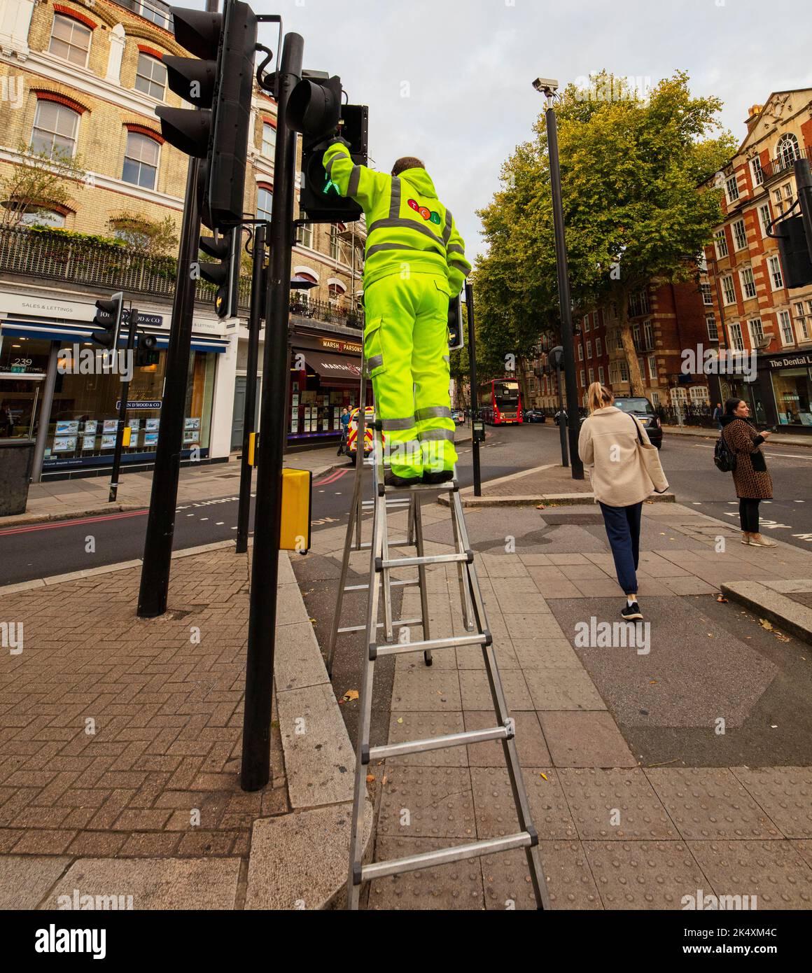 Operaio che ripara il semaforo in Earls Court Rd, Londra Foto Stock