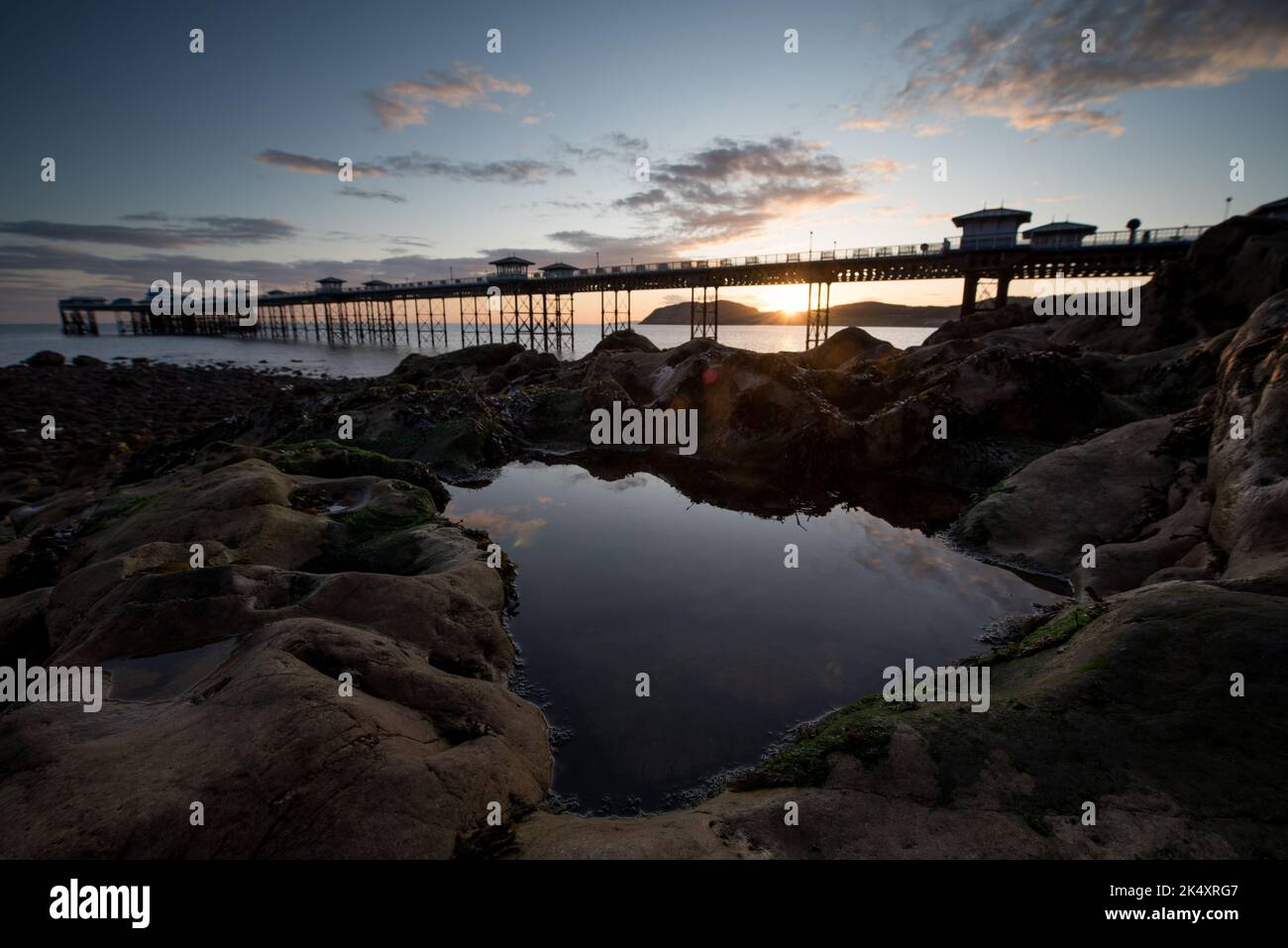 Alba sul Molo di Llandudno. Con la passeggiata vittoriana e il sole che sorge dietro Foto Stock