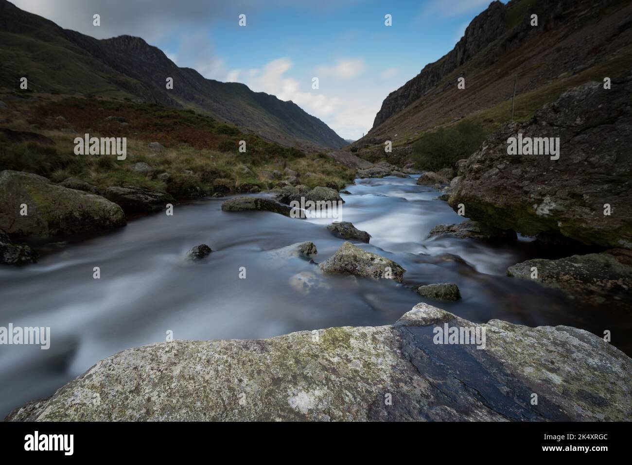 Ruscello che corre giù la montagna con acqua dolce e nebbiosa. Lunga esposizione che scorre acqua Foto Stock