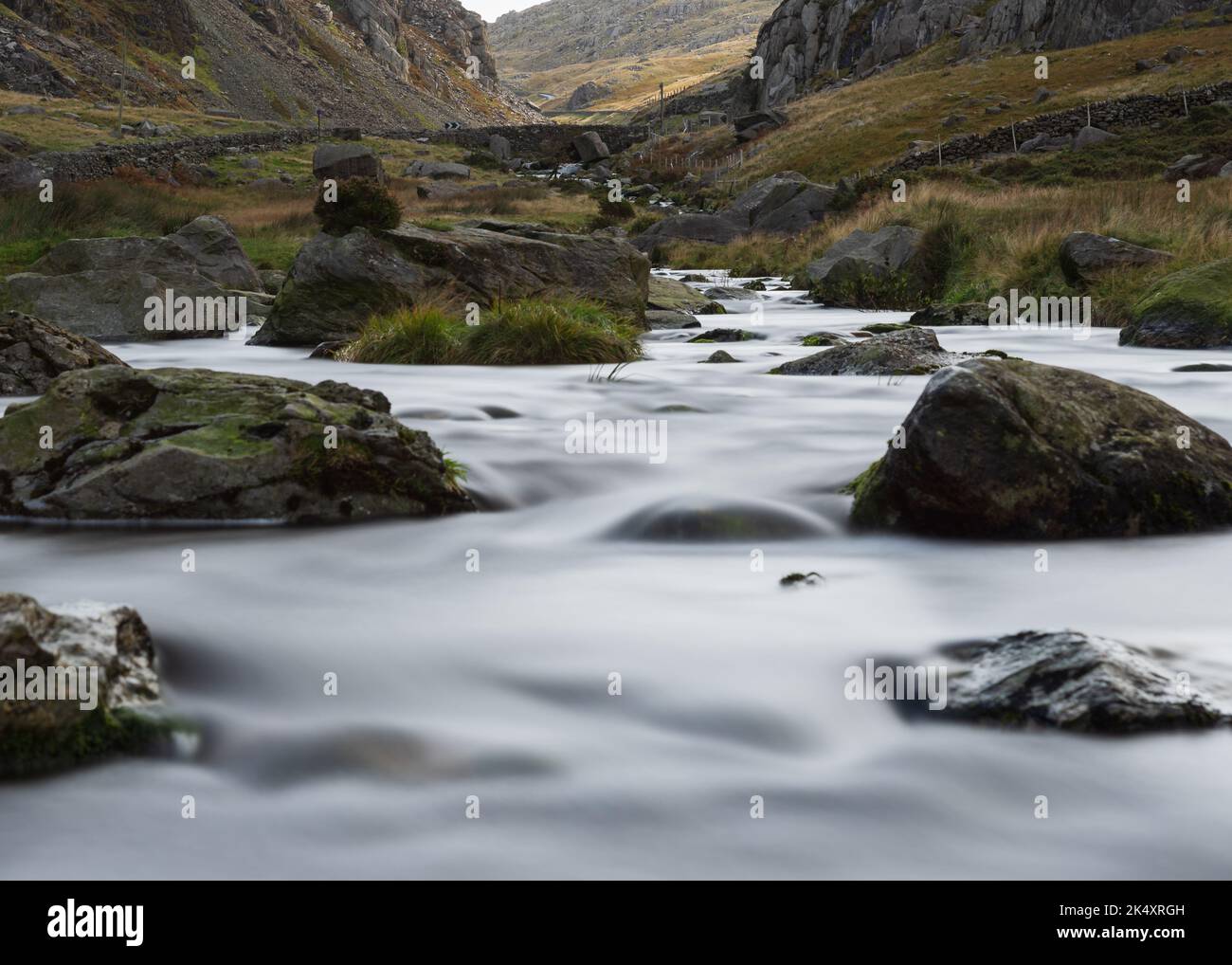 Ruscello che corre giù la montagna con acqua dolce e nebbiosa. Lunga esposizione che scorre acqua Foto Stock