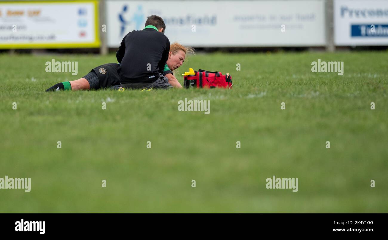 Donne inglesi giocatori amatoriali di Rugby Union che giocano in un gioco di campionato e ricevono cure mediche. Foto Stock