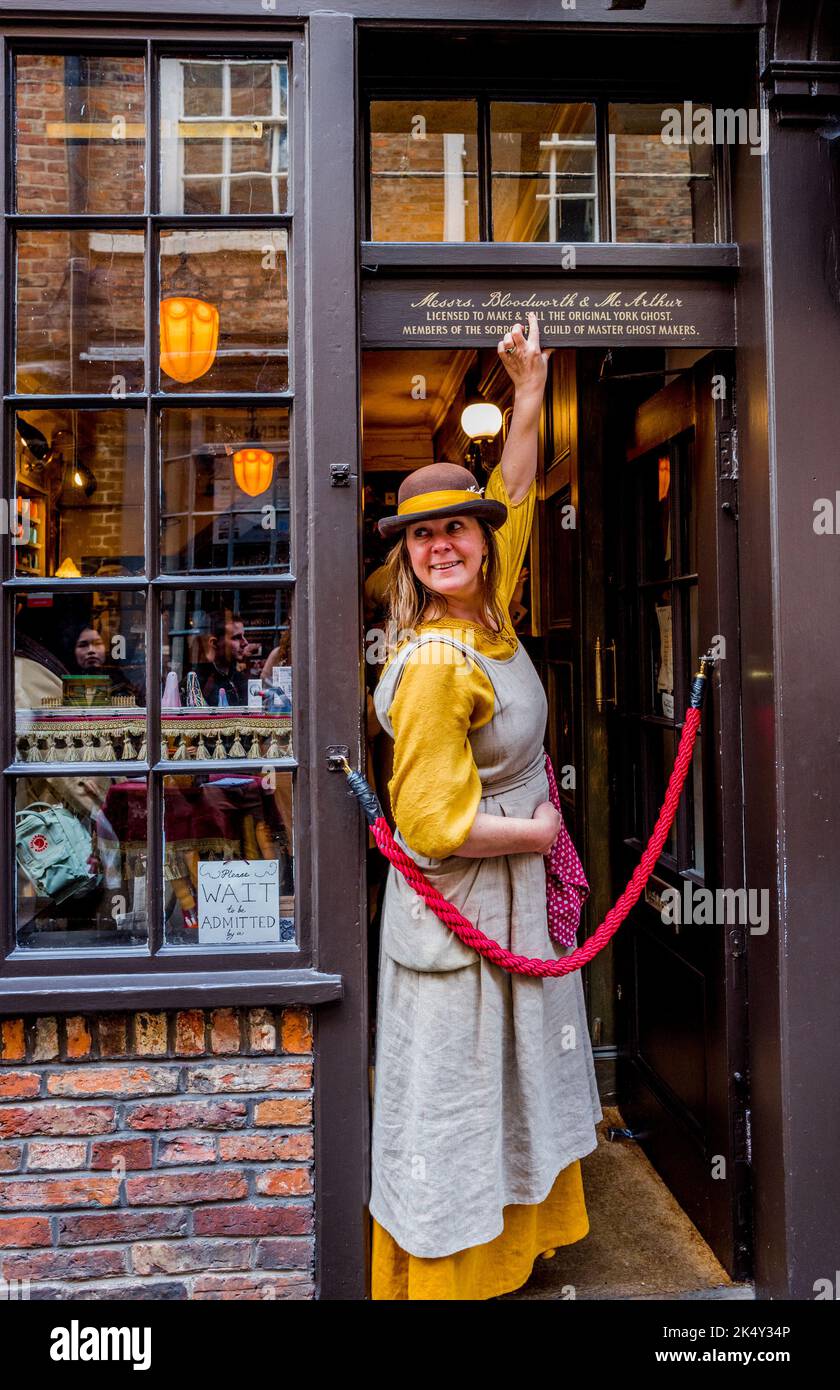 Il proprietario di affari femminile di York Ghost Merchant in piedi fuori del negozio di fantasmi in Shambles, York, Yorkshire, Inghilterra. Foto Stock