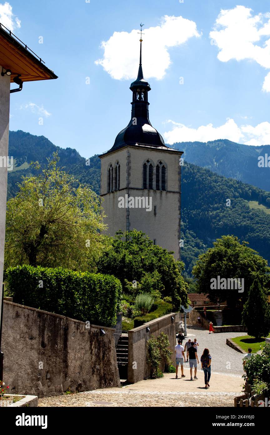 Eglise Saint Theodule in Gruyeres Svizzera con le montagne che si innalzano sullo sfondo Foto Stock