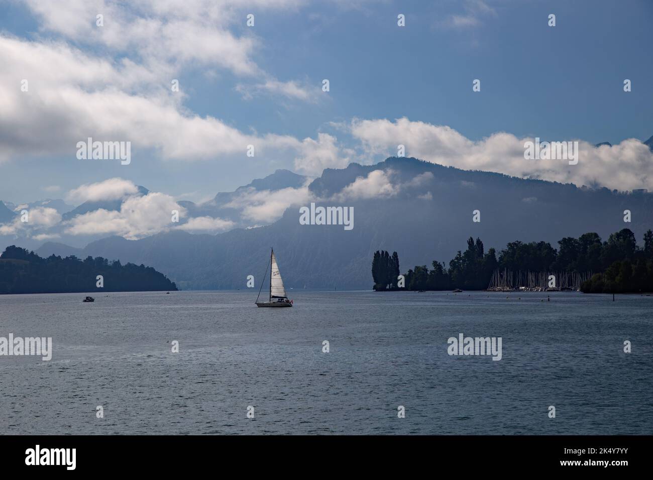 Crociera sul Lago di Lucerna, Svizzera con barca a vela sullo sfondo e montagne sullo sfondo Foto Stock