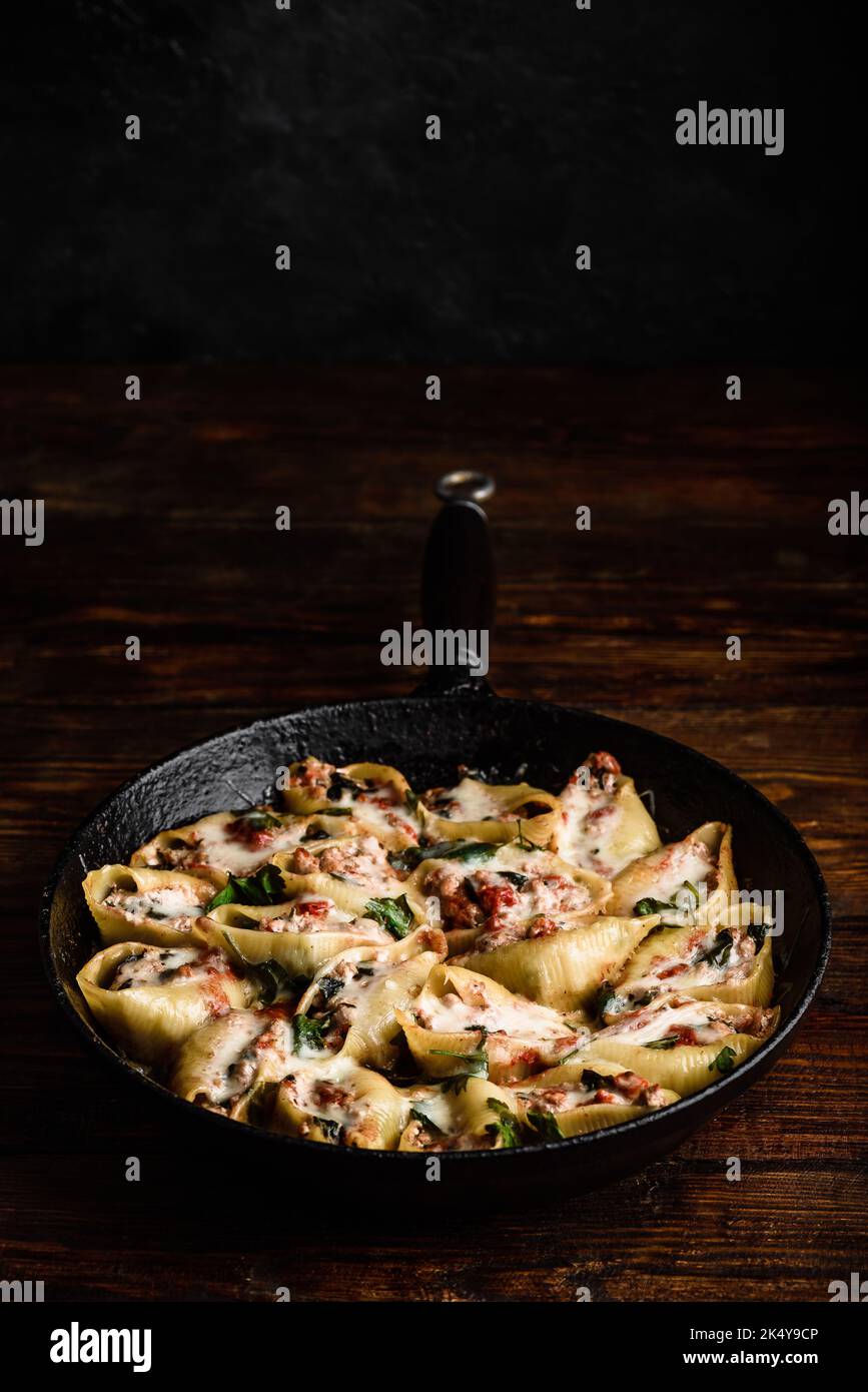 Pailletto di conchiglie di jumbo al forno farcite con manzo macinato, spinaci e formaggio Foto Stock
