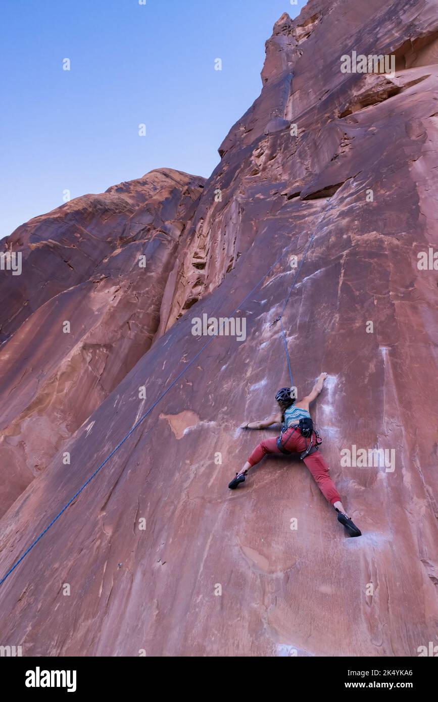 Arrampicata femminile su roccia arenaria vicino a Moab, Utah Foto Stock