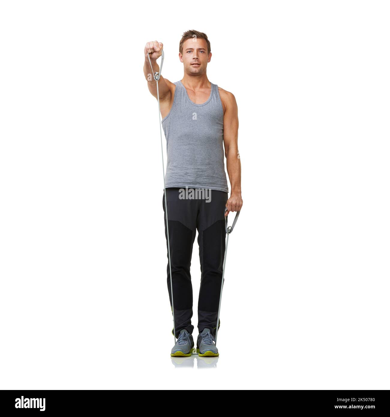Raggiungere per forza e definizione. Un giovane uomo in forma che lavora con una fascia di resistenza mentre isolato su uno sfondo bianco. Foto Stock