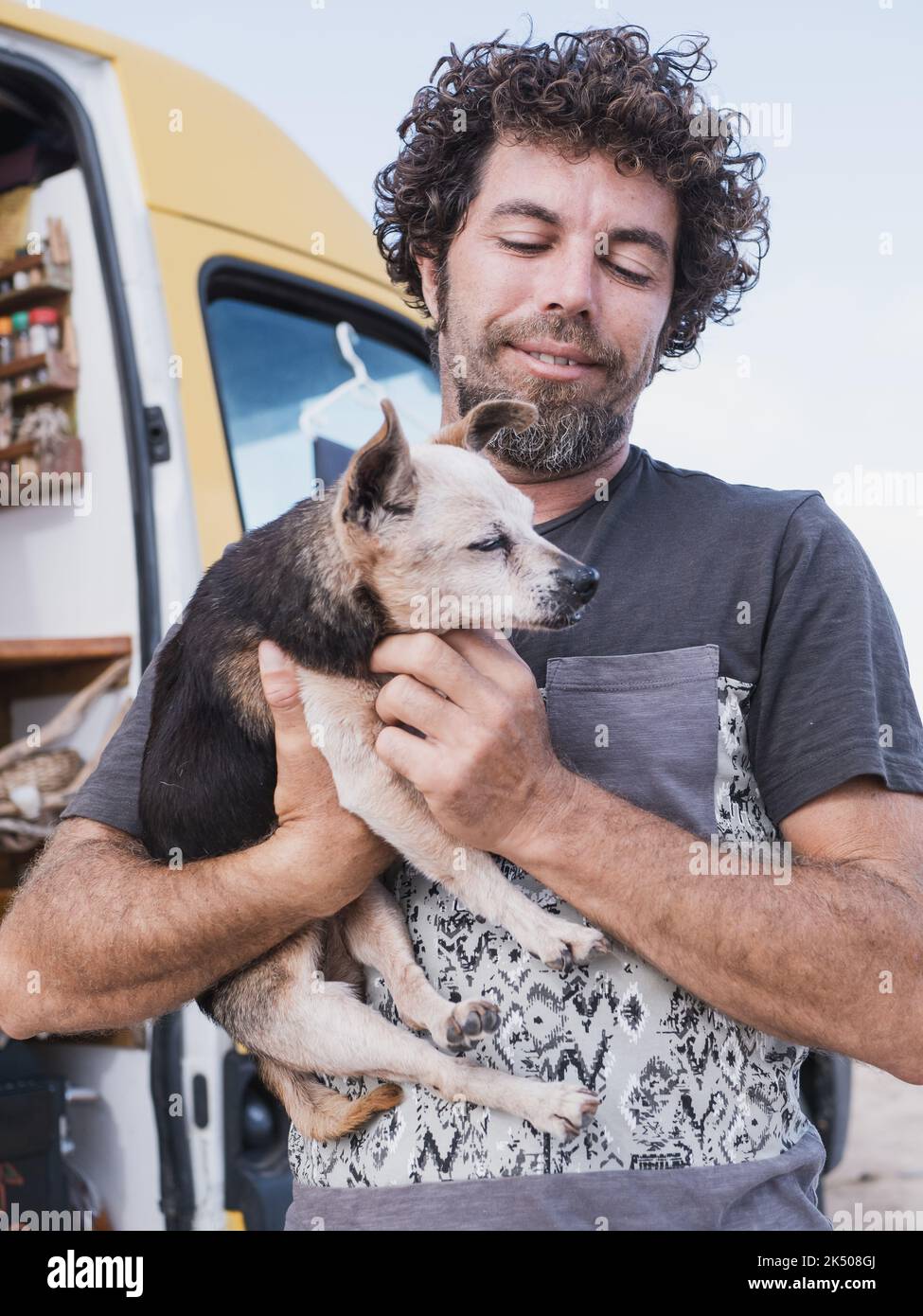 Camper caucasico van nomad tenendo il suo vecchio amico del piccolo cane Foto Stock