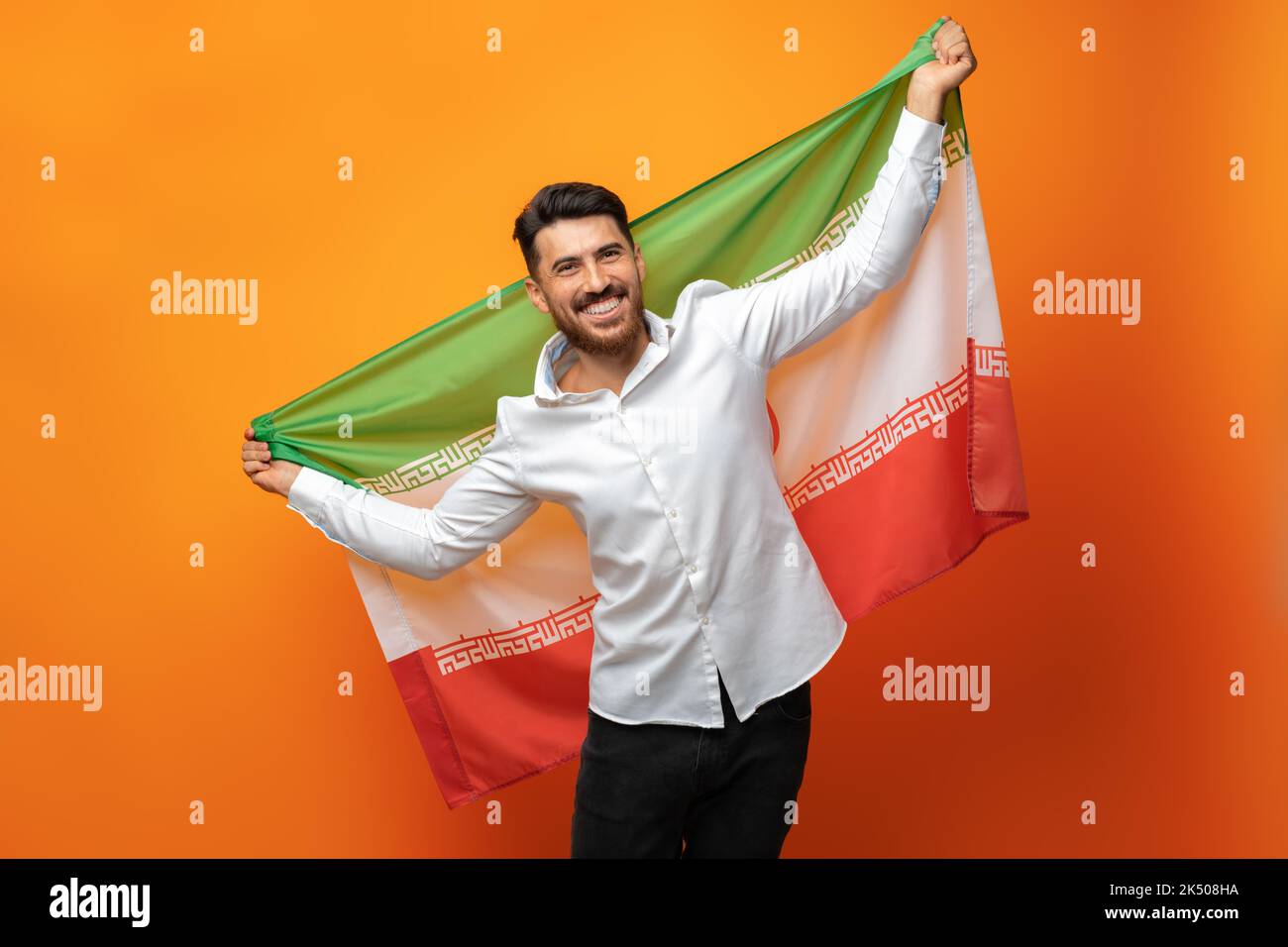 Ritratto di un giovane uomo casual con bandiera dell'Iran su sfondo arancione Foto Stock