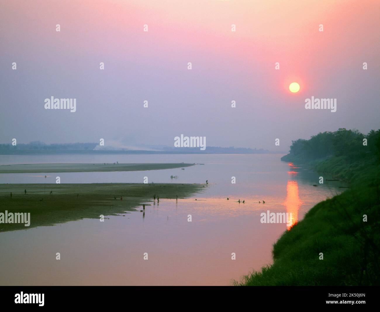 Laos: Pescatori e collezionisti di alghe fluviali lavorano mentre il sole tramonta sul fiume Mekong vicino a Vientiane. Il fiume Mekong è il fiume 12th più lungo del mondo. Dalla sorgente himalayana sull'altopiano tibetano, scorre per circa 4.350 km (2.703 miglia) attraverso la provincia cinese dello Yunnan, la Birmania, il Laos, la Thailandia, la Cambogia e il Vietnam, Infine drenando nel Mar Cinese Meridionale. Foto Stock