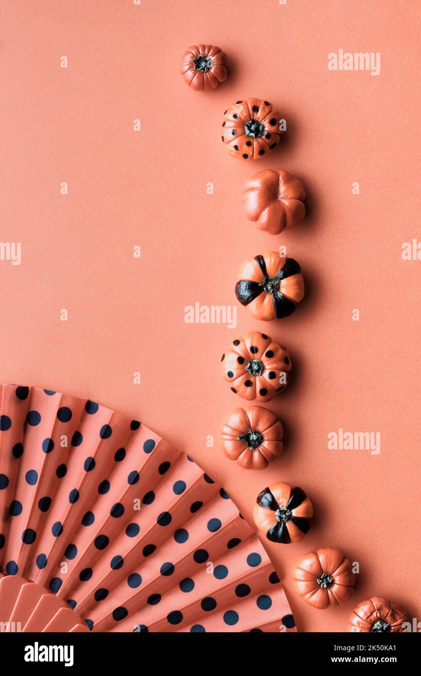 Carino sfondo verticale di Halloween. Modello nero arancione per storie sui social media. Zucche in mini deco dipinte e ventilatore con pois di polka. Foto Stock