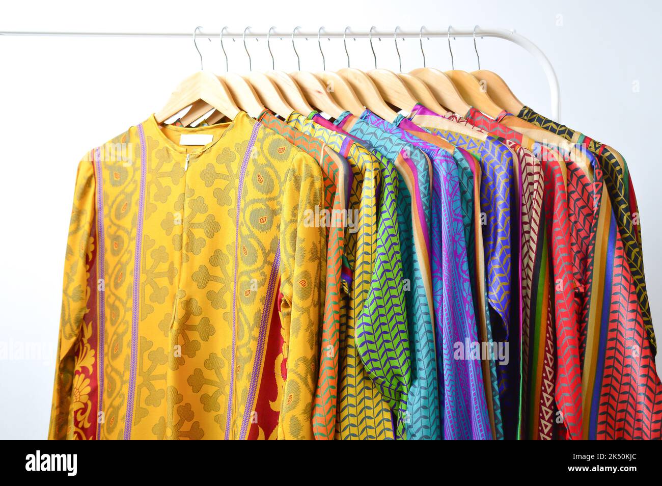 Abbigliamento alla moda in un negozio boutique. Vestiti colorati isolati con sfondo bianco. Foto Stock