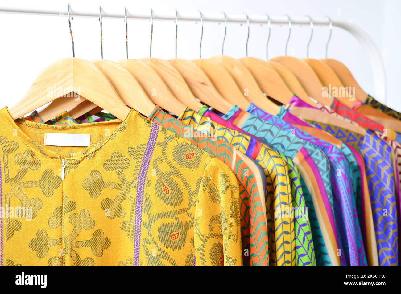 Abbigliamento alla moda in un negozio boutique. Vestiti colorati isolati con sfondo bianco. Foto Stock