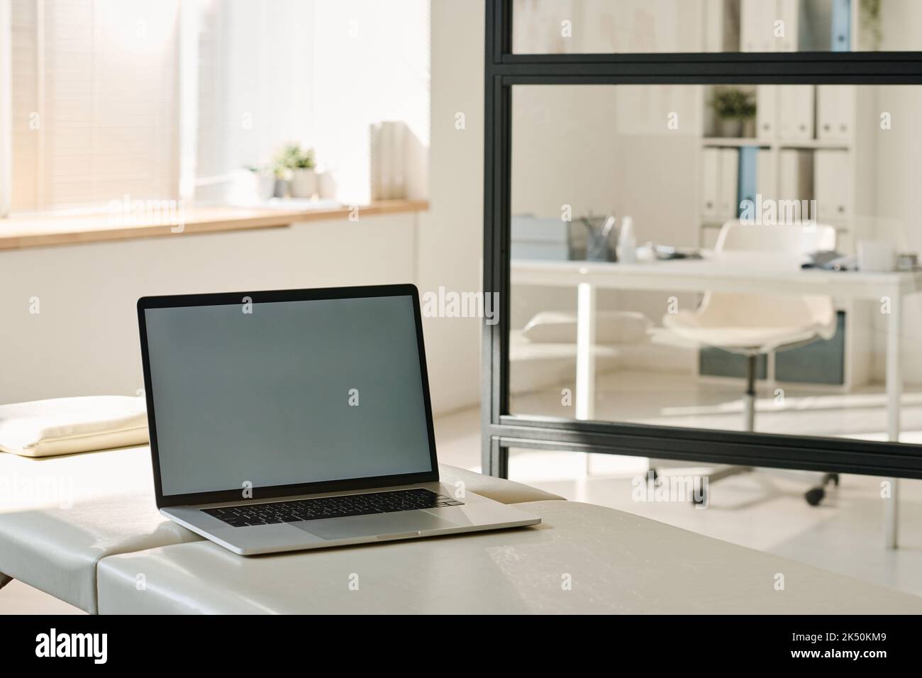 Primo piano di un computer portatile per il lavoro online sul tavolo presso un ufficio medico Foto Stock