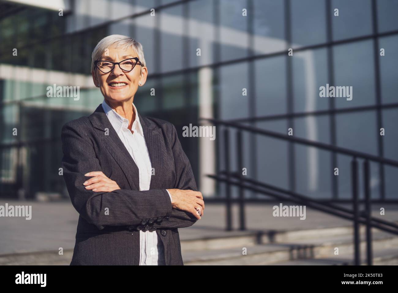Ritratto all'aperto di una donna d'affari senior di successo di fronte alla costruzione dell'azienda. Foto Stock