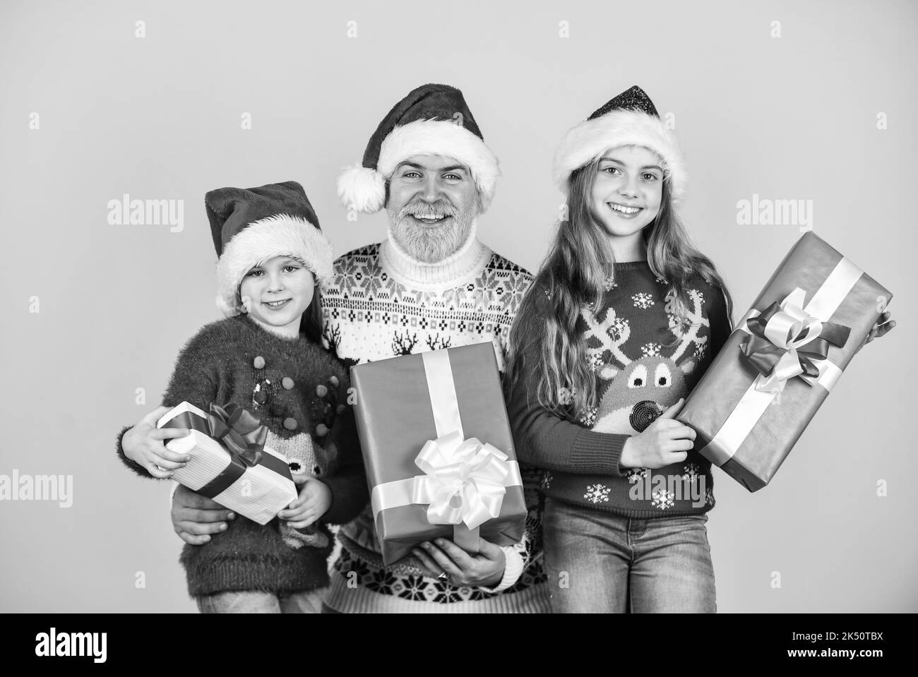 Divertimento di Natale. babbo santa uomo con i capretti. Moda a maglia per l'inverno. Shopping di nuovo anno. Tempo per i regali. Famiglia felice festeggia Natale. Piccole ragazze Foto Stock