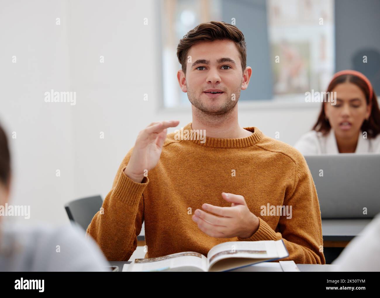 Studente universitario, docente e in classe per domande, parlare o parlare di risultati di ricerca, libro di sintesi o corso di formazione. Giovane uomo che impara Foto Stock