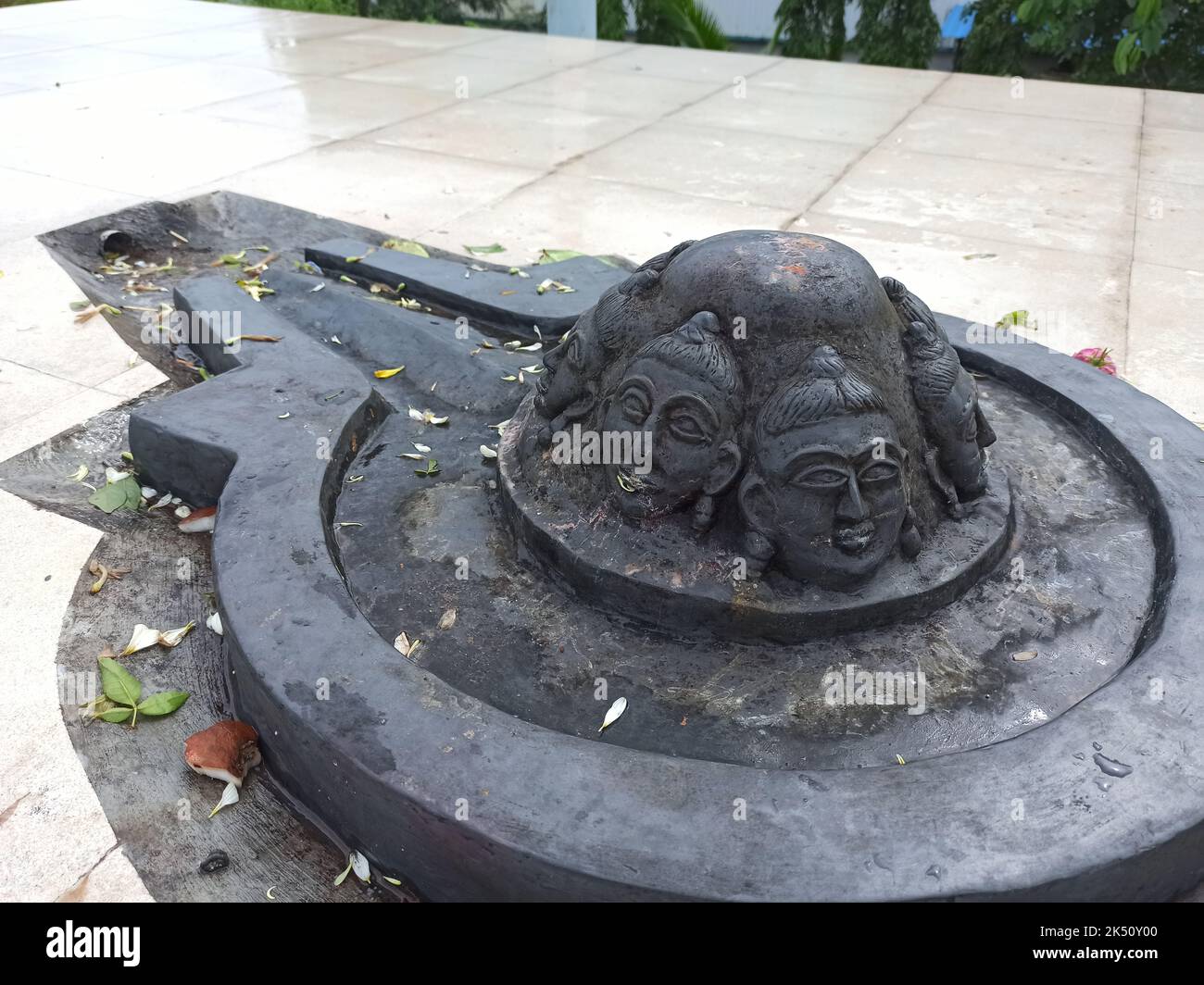 Una Shiva linga fatta con una pietra nera su superficie piana con circostante fatto di piastrelle Foto Stock