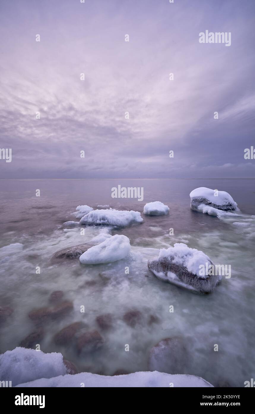 Un mare magico coperto da ghiaccio e neve, esposizione lunga, verticale Foto Stock