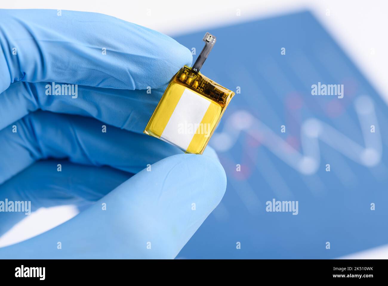 Piccola batteria ricaricabile agli ioni di litio con connettore per orologio intelligente o dispositivo indossabile in mano scienziata in laboratorio Foto Stock