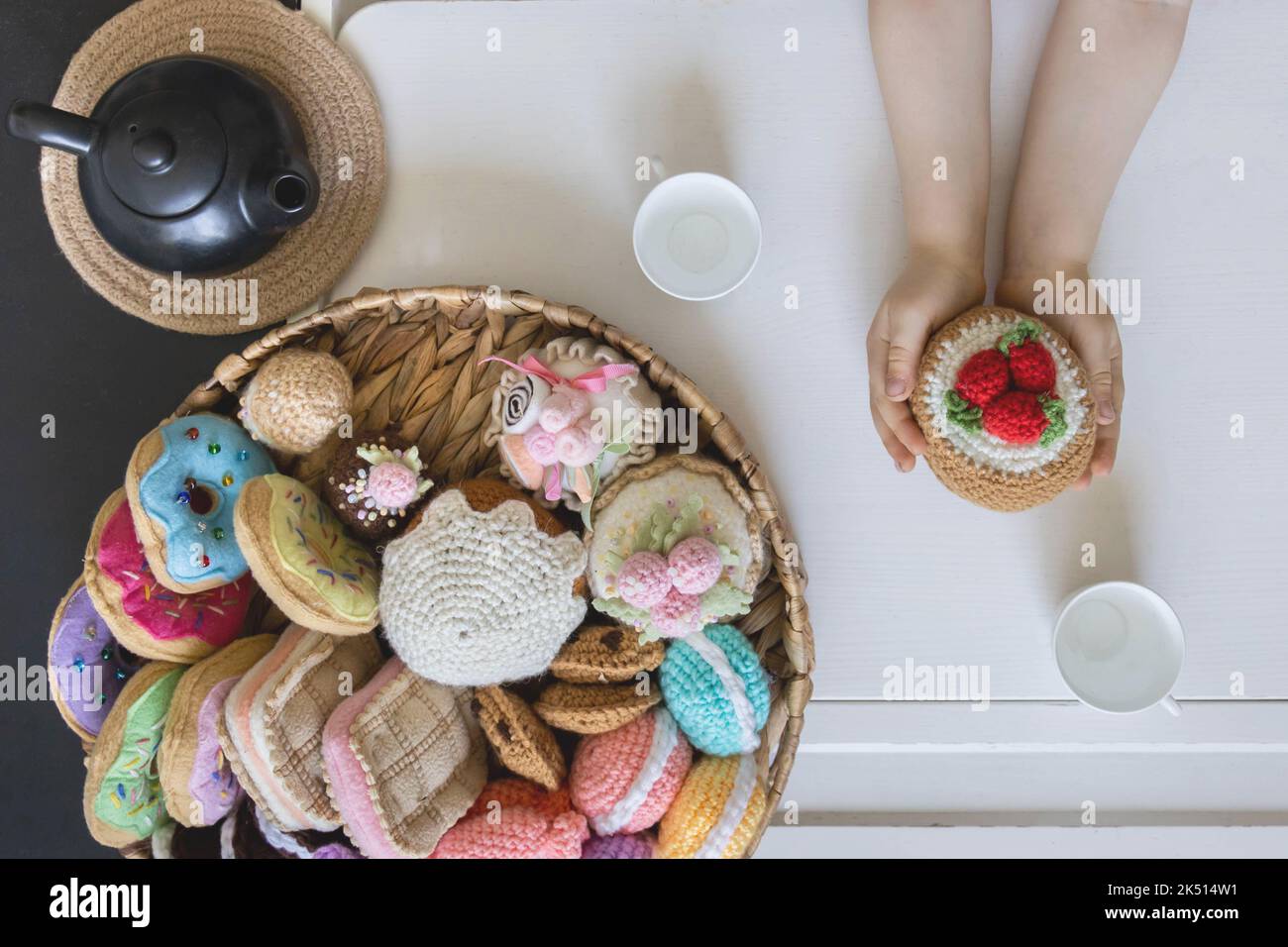 Cibo giocattolo lavorato a maglia da filato. Dolci, dolci, biscotti e torte. Foto Stock