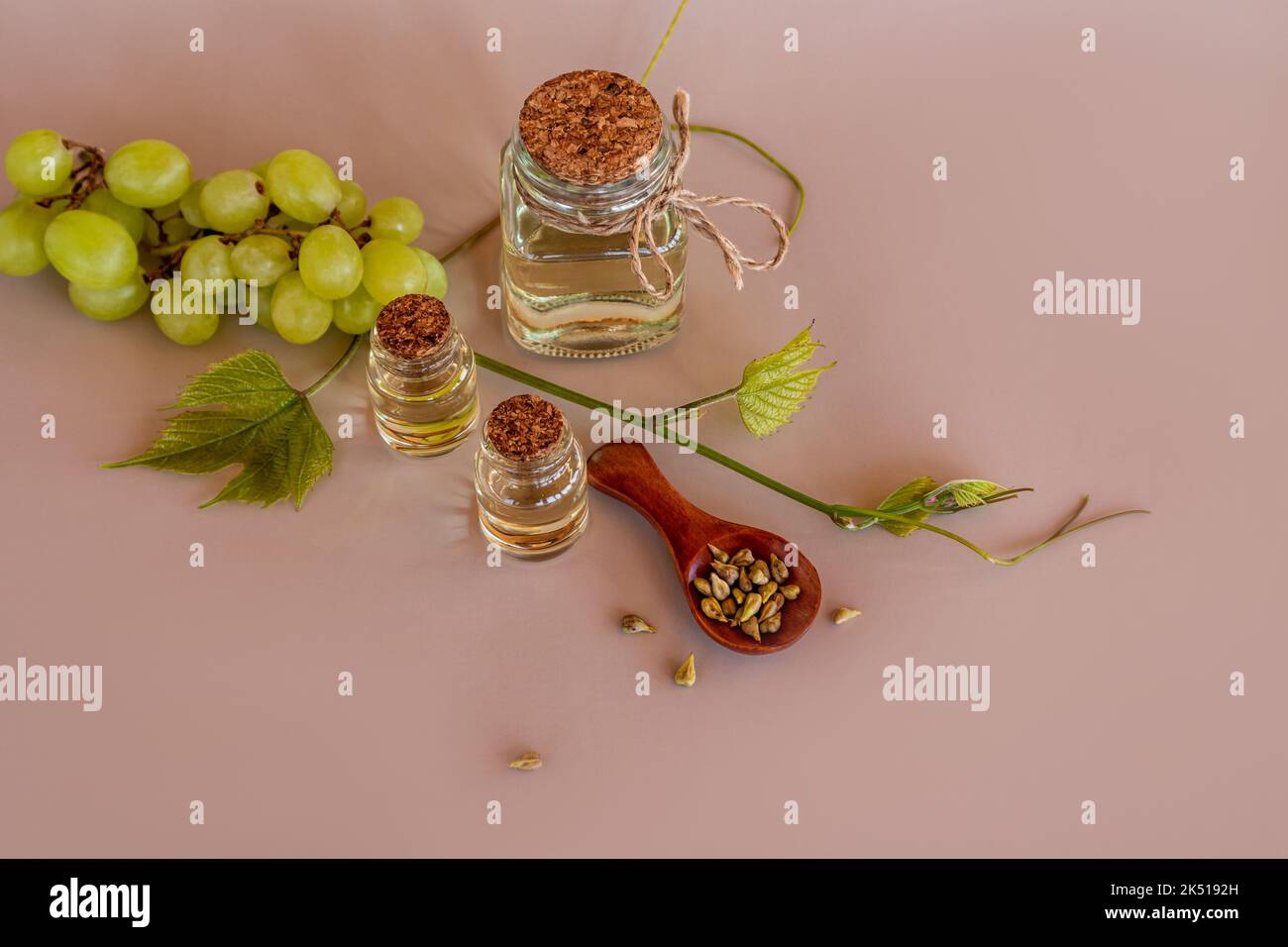 olio d'uva, un rimedio dai semi d'uva in una bottiglia trasparente di vetro con un sughero. rallenta il processo di invecchiamento, la fontana della gioventù. Foto Stock