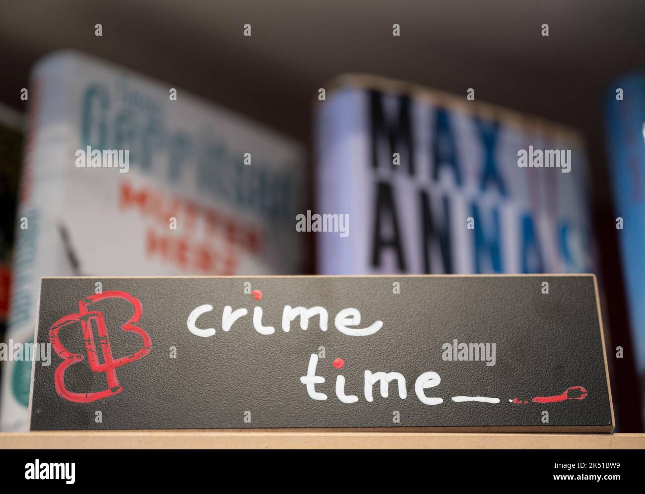 26 settembre 2022, Hessen, Francoforte sul meno: ILLUSTRAZIONE - Un cartello con la scritta 'Crime Time' si trova sullo scaffale dei romanzi del crimine nella libreria 'Bücher im Bogen' di Francoforte sul meno. Foto: Boris Roessler/dpa Foto Stock