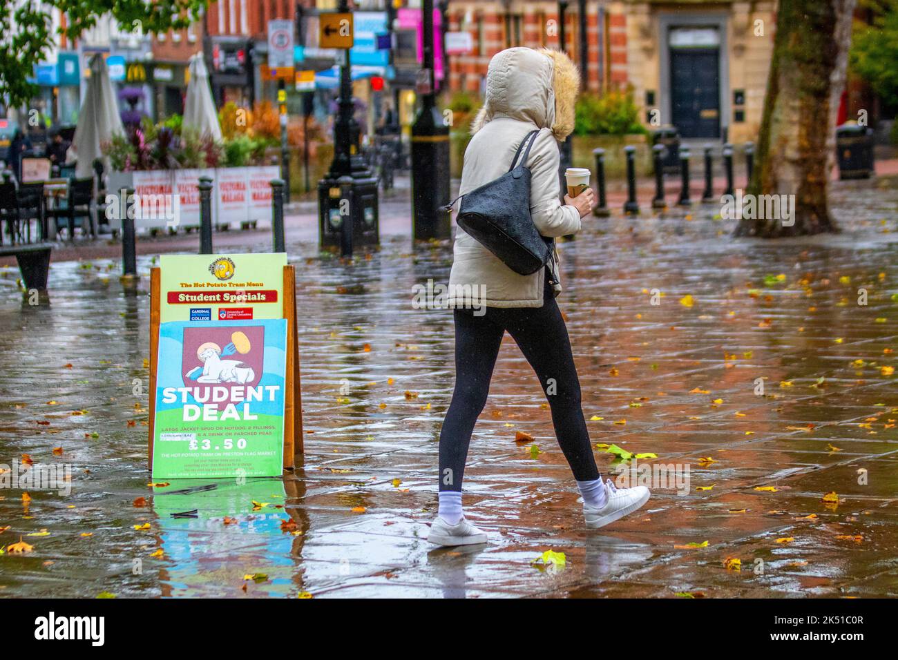 Offerta pasto studente in una giornata di pioggia a Preston. Regno Unito Meteo ottobre, 2022; bagnato e ventoso inizio della giornata nel nord-ovest dell'Inghilterra. Una giornata ventosa con nuvole variabili e docce sparse e blustery, alcune delle quali saranno pesanti. Credit; MediaWorldImages/AlamyLiveNews Foto Stock