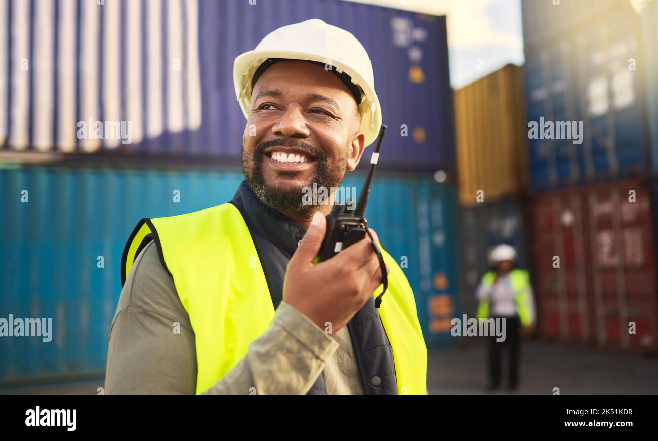 Uomo nella logistica che parla alla radio, la comunicazione nell'industria di trasporto e di trasporto con un sorriso. Organizzazione di merci commerciali, e-commerce Foto Stock