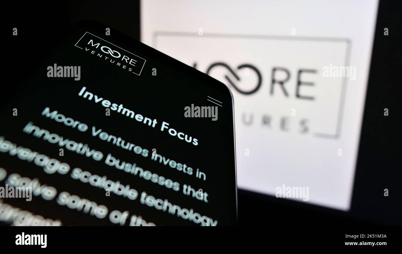Smartphone con pagina Web della società di investimento statunitense Moore Ventures sullo schermo di fronte al logo aziendale. Messa a fuoco in alto a sinistra del display del telefono. Foto Stock