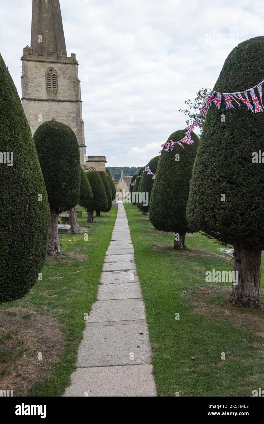 Il cortile della chiesa di St. Mary a Painswick, Gloucestershire, è famoso per i suoi alberi di tasso Foto Stock