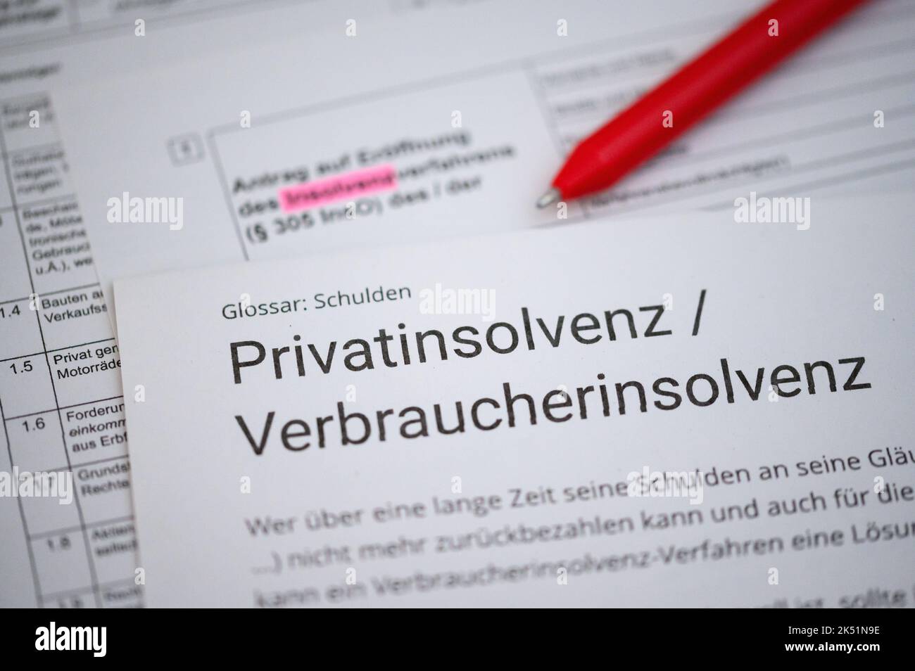 PRODUZIONE - 26 settembre 2022, Amburgo: Una penna a sfera si trova su una domanda di apertura di una procedura di insolvenza e un testo informativo sull'insolvenza privata / insolvenza dei consumatori. Foto: Jonas Walzberg/dpa Foto Stock