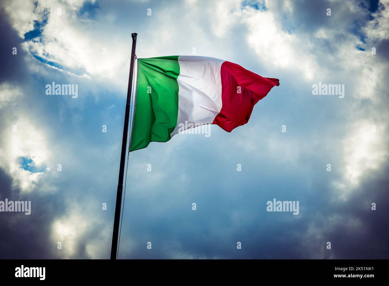 Bandiera nazionale italiana che vola contro il cielo nuvoloso Foto Stock