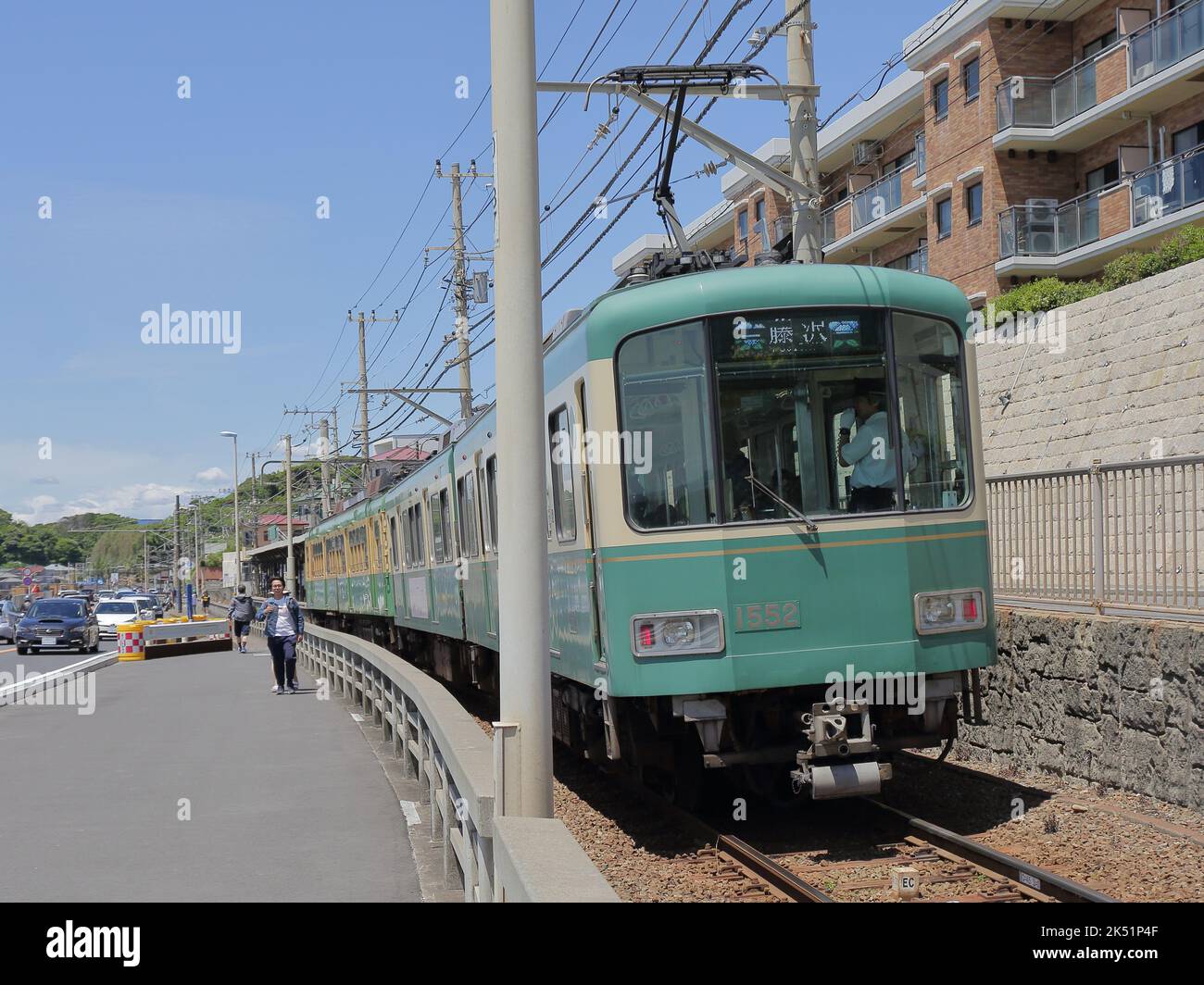 Il treno della Ferrovia elettrica di Enoshima passa attraverso il passaggio di livello dove è una famosa attrazione per i fan di Slam Dunk vicino alla Stazione di Kamakurakokomae Foto Stock