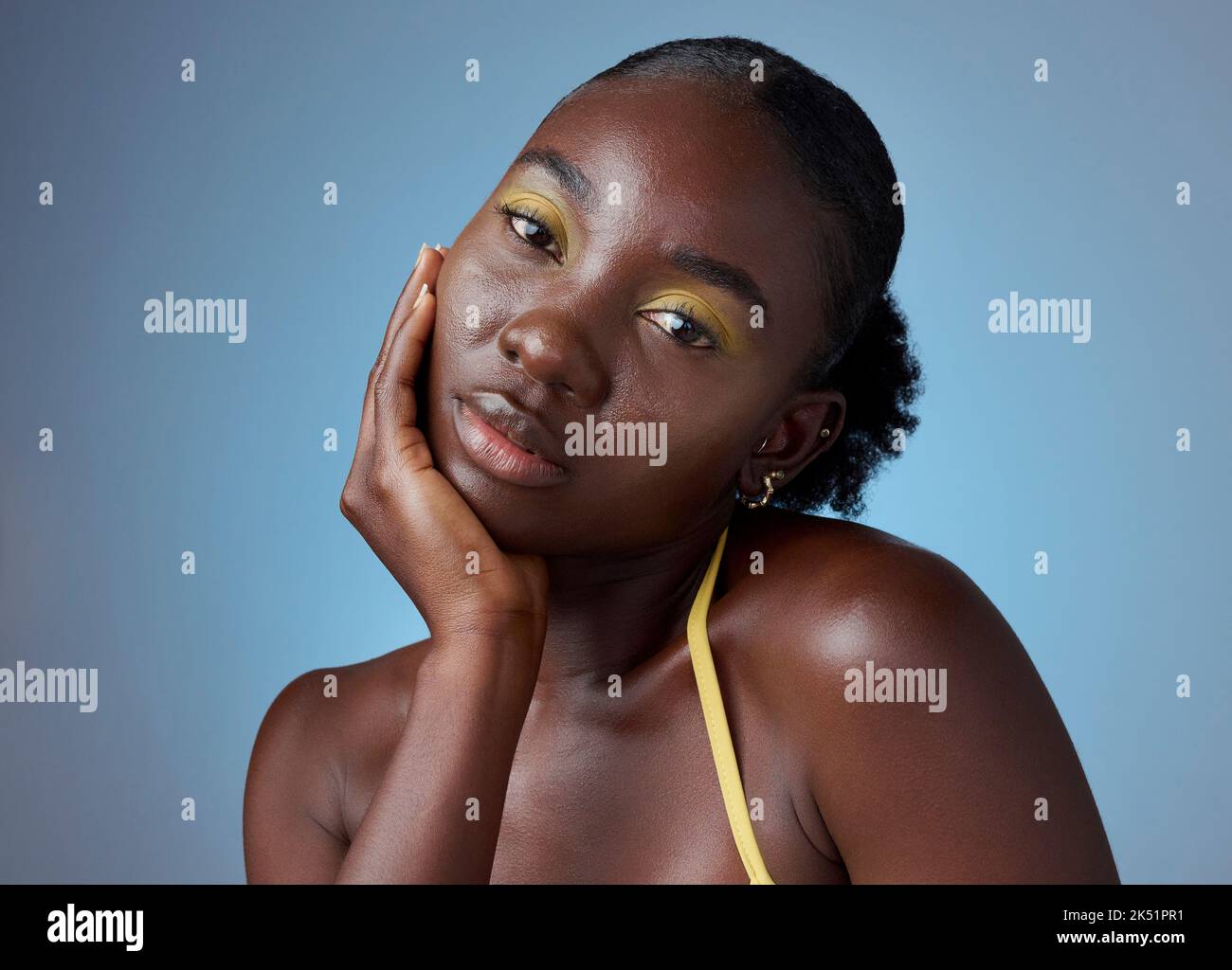 Trucco viso, ritratto creativo e donna nera con luce da cosmetici su uno sfondo blu mockup studio. Modello africano con bellezza da Foto Stock