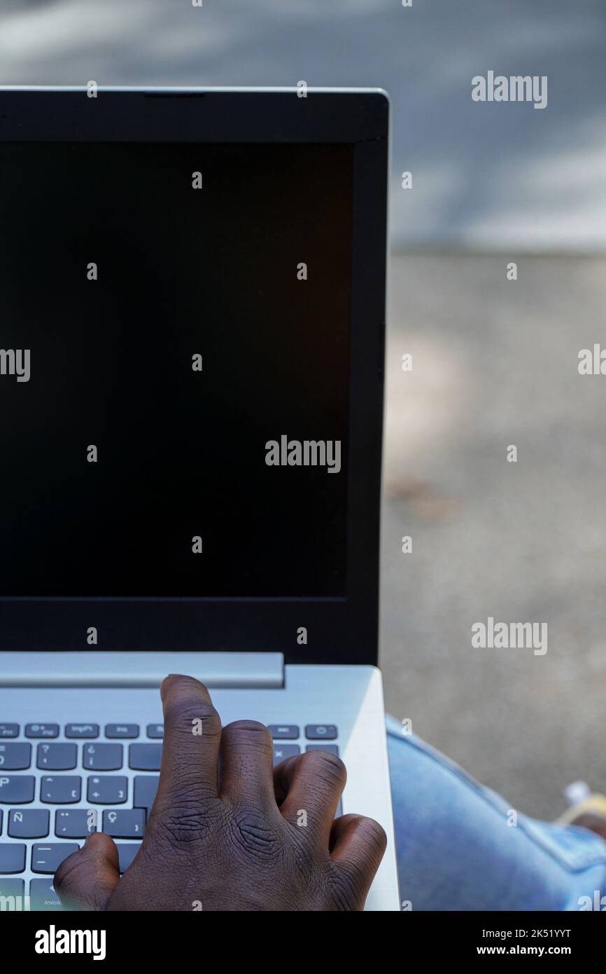 lavoro online. Persona nera che lavora con un notebook. Nomade digitale Foto Stock