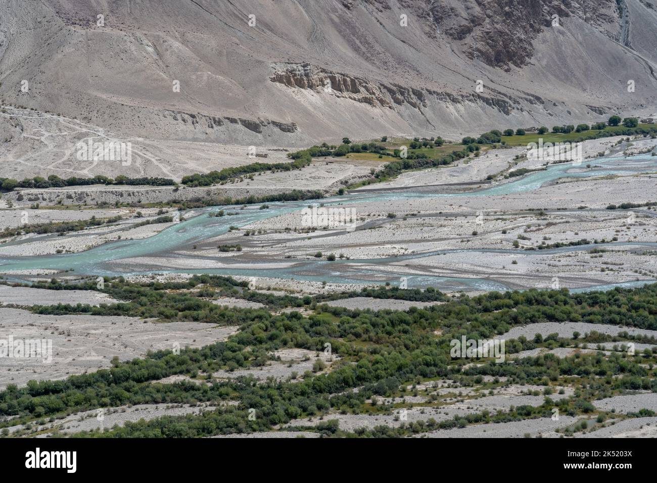 Vista panoramica ad alta quota del bel fiume Pamir verde e blu che confina con l'Afghanistan nel corridoio di Wakhan, vicino a Langar, Gorno-Badakshan, Tagikistan Foto Stock