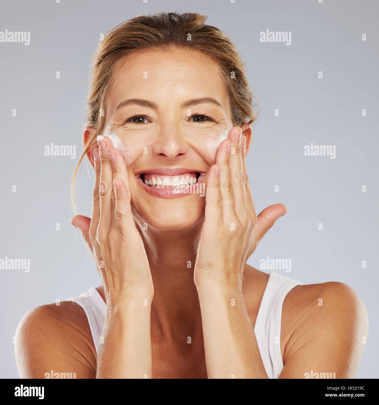 Maturo bellezza ritratto, viso lavaggio e felice donna incandescente dermocosmesi, dermatologia e anti invecchiamento cosmetici su sfondo grigio studio. Signora Canada felice Foto Stock