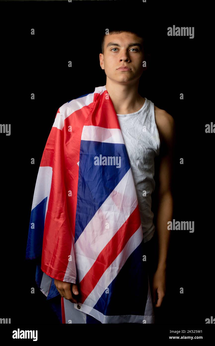 Ritratto di un ragazzino di diciannove anni su sfondo nero con bandiera britannica Foto Stock