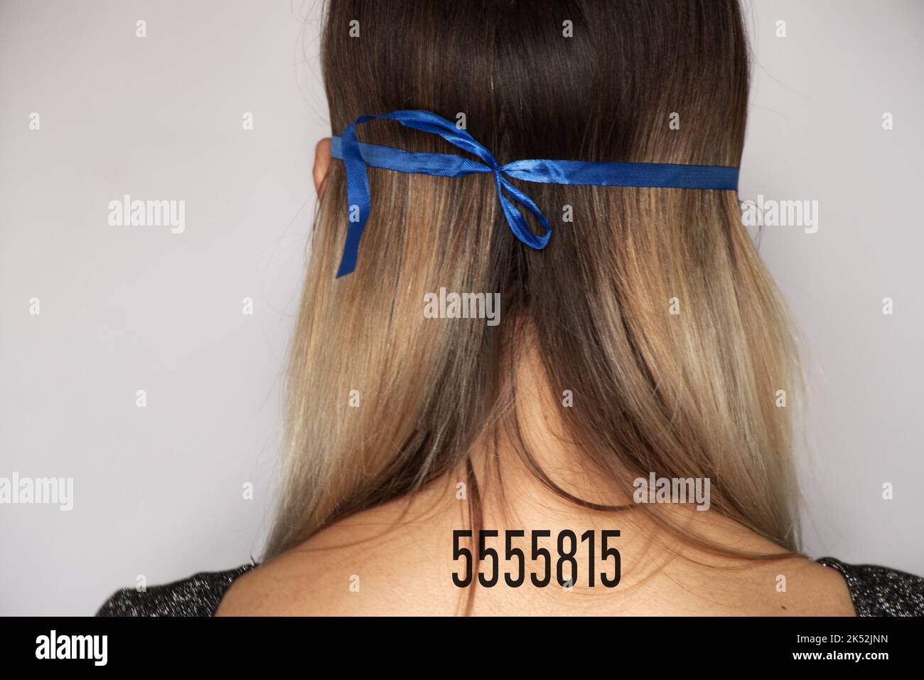 ragazza con un numero di serie sulla schiena, numero personale di una persona, non libertà, mancanza di volontà, numero di serie di una persona per la vita, la schiena della ragazza Foto Stock