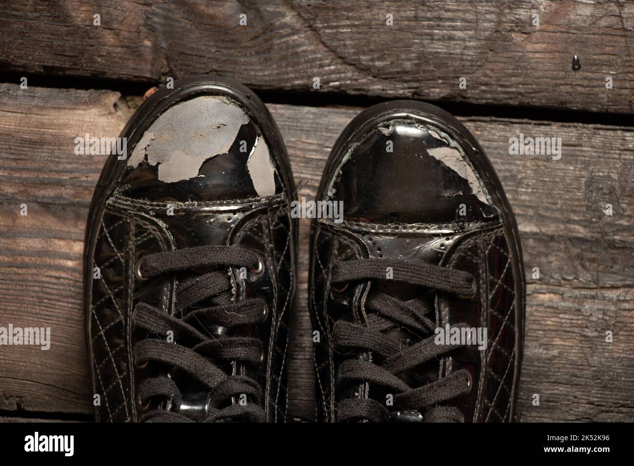 vecchie scarpe lacerate in vernice su un pavimento di legno, scarpe da donna, scarpe strappate Foto Stock