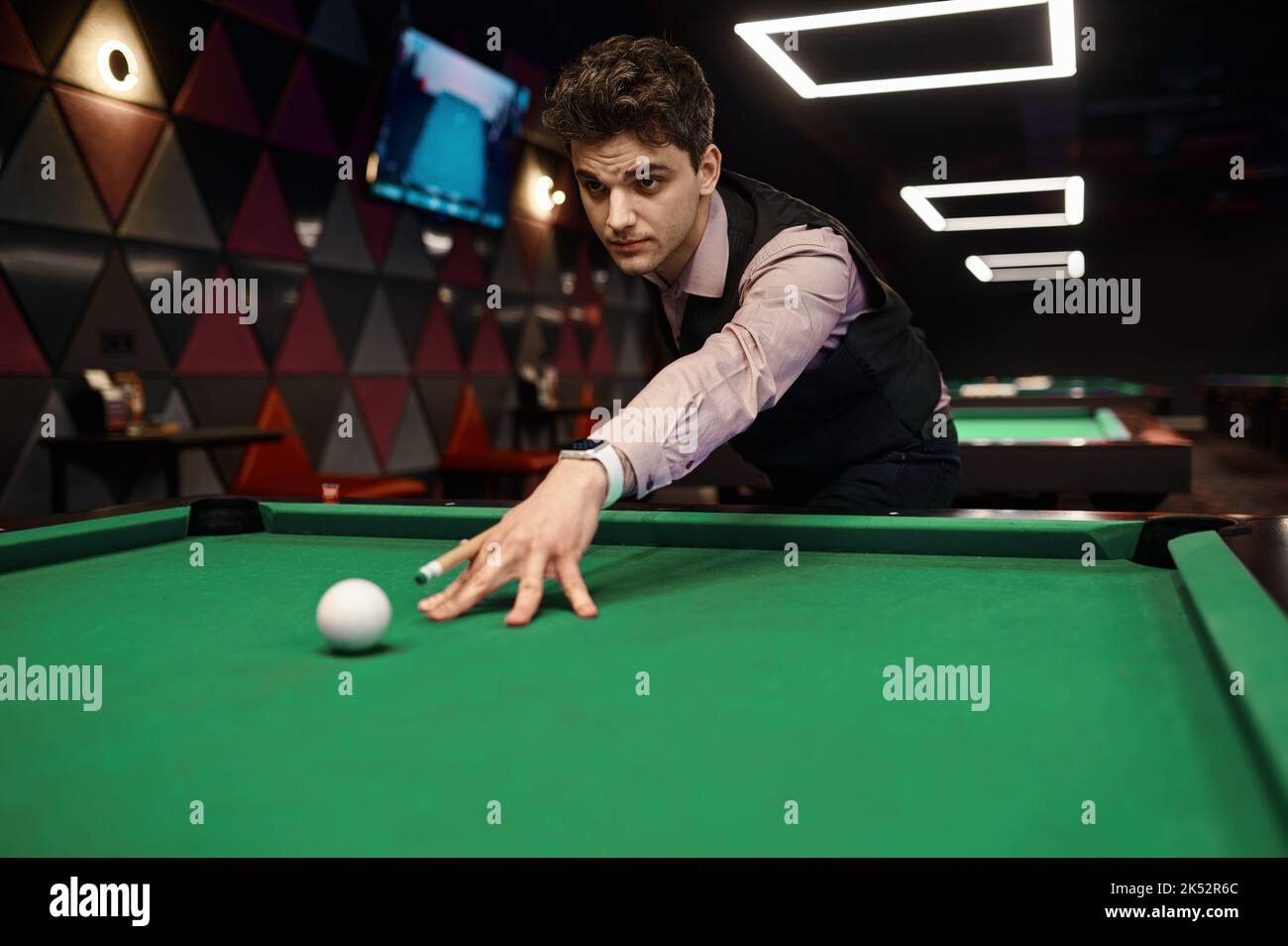 Ritratto di giovane uomo puntato con stecca da biliardo Foto Stock