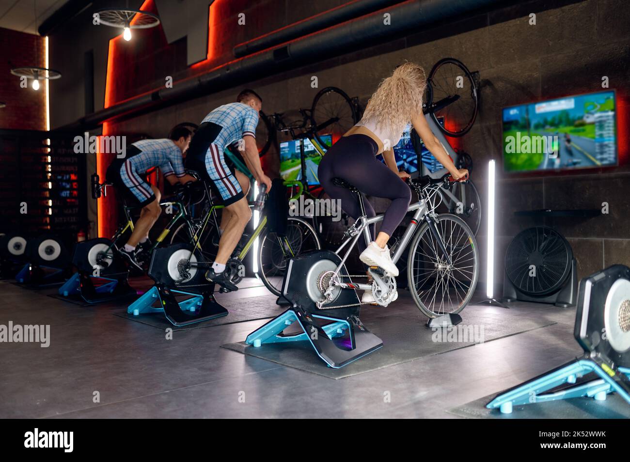 Gruppo di sportivi in bici stazionaria in palestra Foto Stock