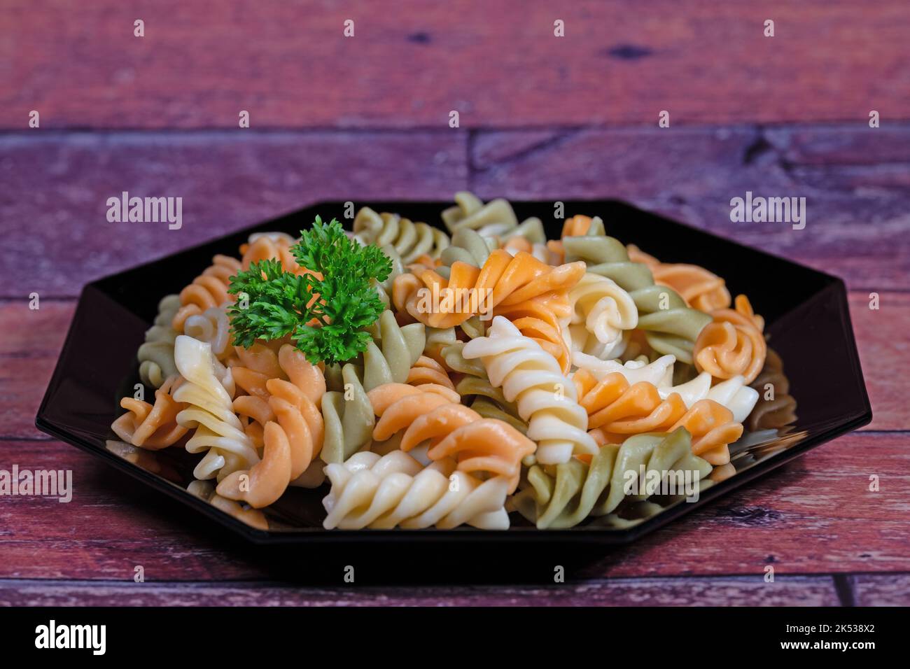 Pasta colorata a spirale su un piatto Foto Stock