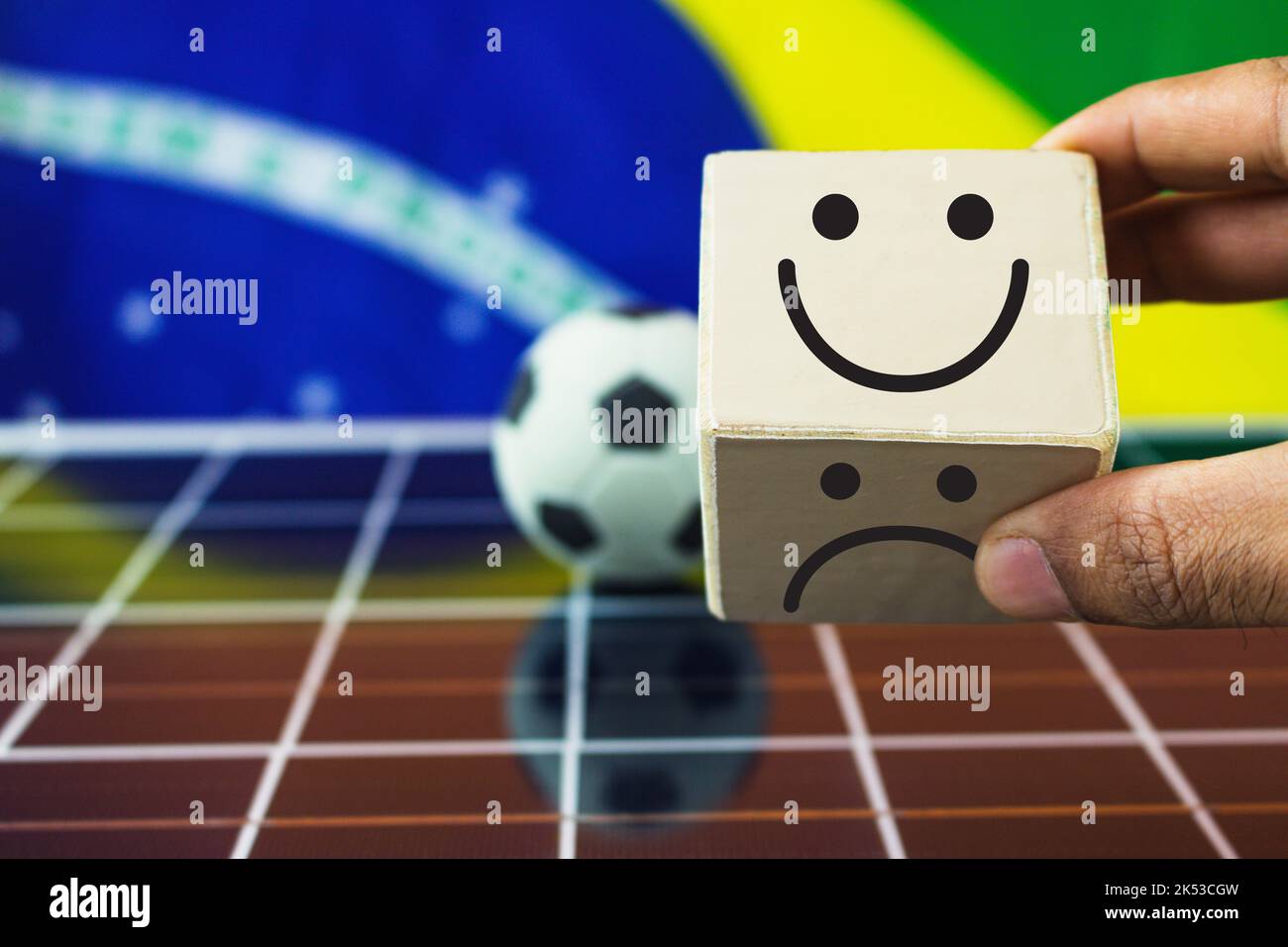 La mano mette i cubi di legno con il viso sorridente e il viso triste e Brazil Flag sul pannello solare fotovoltaico. Foto Stock