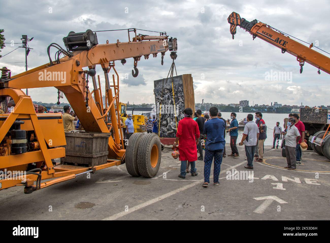 Il lavoro di immersione di Durga idol è in corso a Ganga Ghat di Kolkata. Il grande idolo viene portato al fiume da una gru. Foto Stock