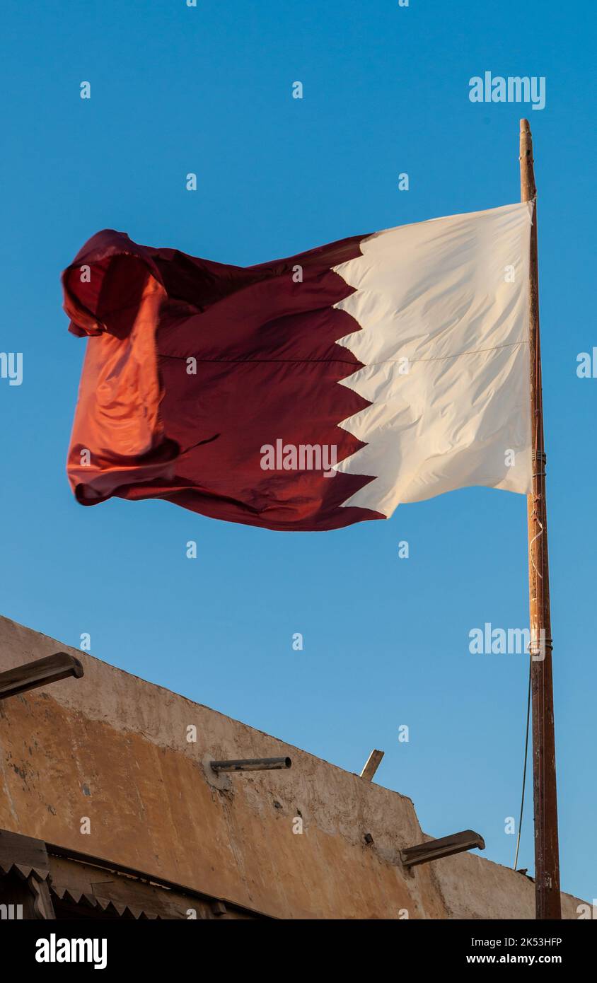 Bandiera del Qatar contro un cielo blu Foto Stock