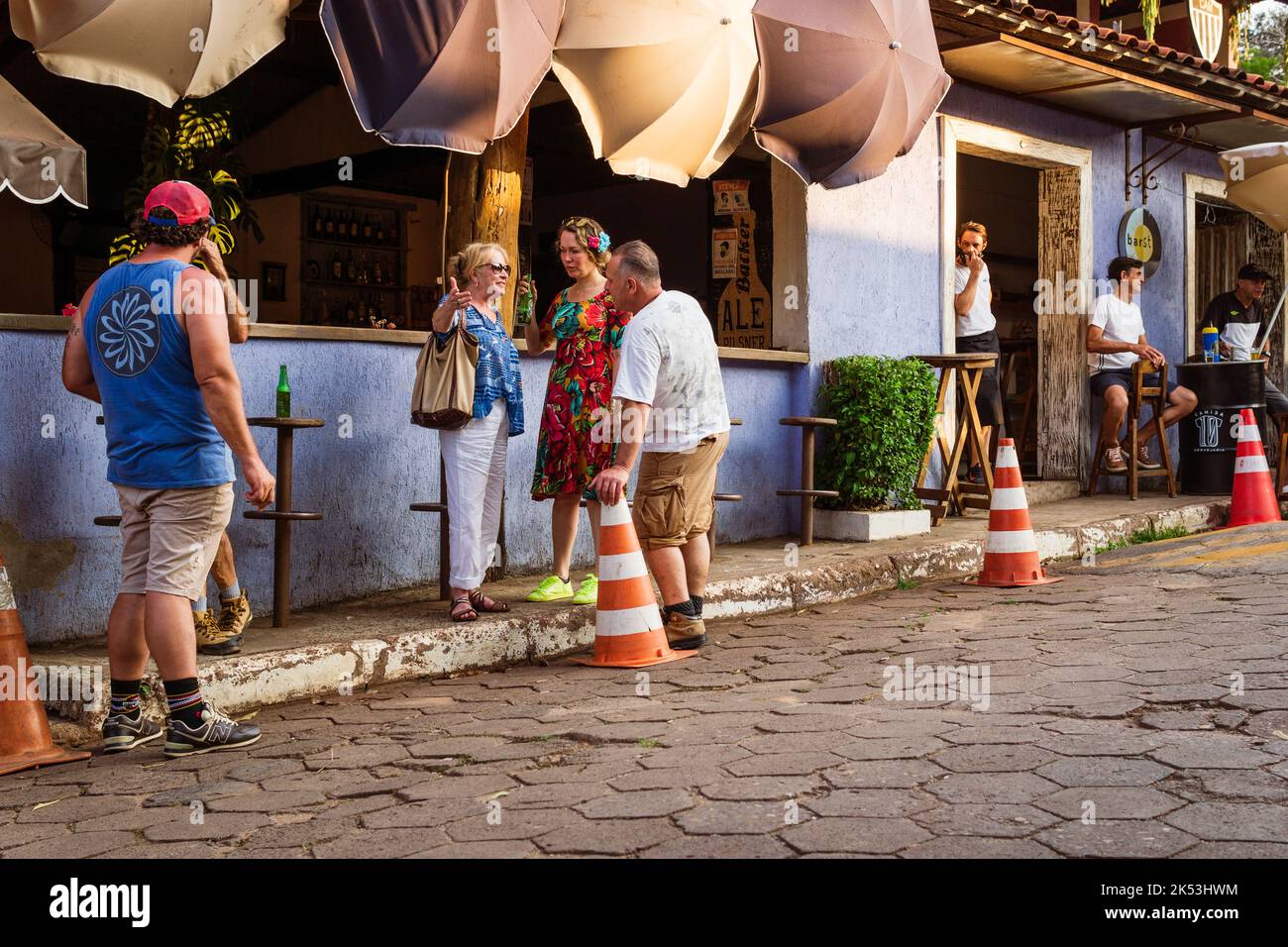 Persone in piedi e parlare di fronte a un ristorante sulla strada principale in São Sebastião das Águas Claras, Macacos, Minas Gerais, Brasile. Foto Stock